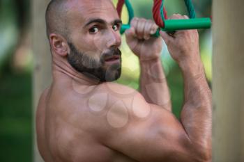 Close-Up Muscular Built Young Athlete Working Out In An Outdoor Gym - Doing Chin-Ups