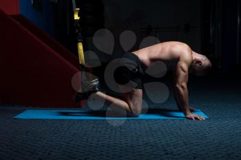 Attractive Man Does Push Ups With Trx Fitness Straps In The Gym's Studio