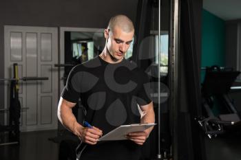 Portrait Of A Personal Trainer In The Gym With Clipboards In His Hands