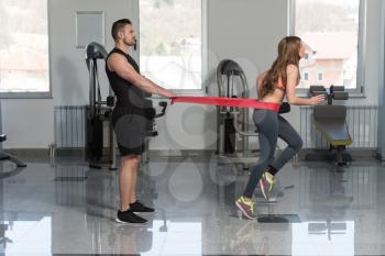 Young Couple Train Together With Resistance Bands A Leg Exercise In A Health And Fitness Concept