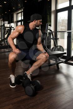 Muscular Man Doing Heavy Weight Exercise For Biceps With Dumbbells In Modern Gym