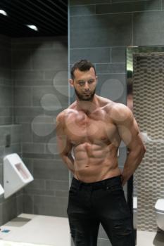 Portrait Of A Physically Fit Man Posing In A Bathroom