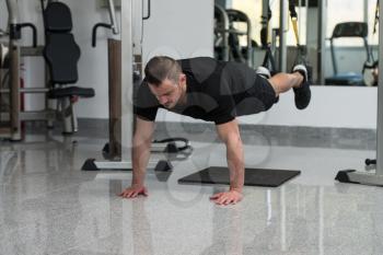 Attractive Young Man Does Crossfit Push Ups With Trx Fitness Straps In The Gym's Studio
