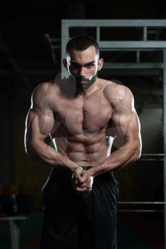 Portrait Of A Young Physically Fit Man Making Most Muscular Pose - Muscular Athletic Bodybuilder Fitness Model Posing After Exercises