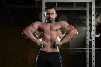 Portrait Of A Young Fit Man Performing Front Lat Spread Pose - Muscular Athletic Bodybuilder Fitness Model Posing After Exercises