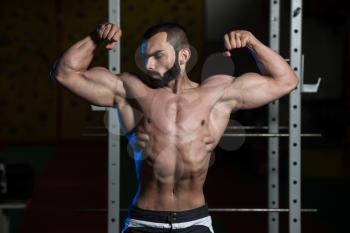 Portrait Of A Young Fit Man Performing Front Double Biceps Pose - Muscular Athletic Bodybuilder Fitness Model Posing After Exercises