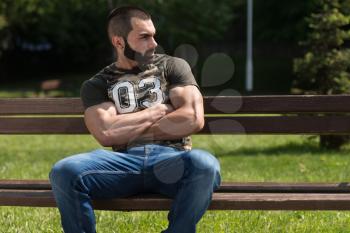 Man In A Shirt Sitting In The Park And Relaxing