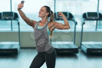 Pretty Mixed Race Woman Taking A Selfie In Fitness Center - Gym In The Background