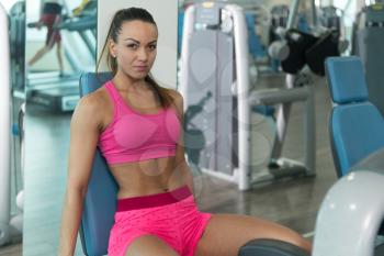 Young Fitness Woman Working Out Legs On Machine In A Fitness Center - Leg Exercise