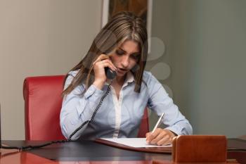 Beautiful Young Woman Working Taking Notes And Talking On Phone- Businesswoman Working Online