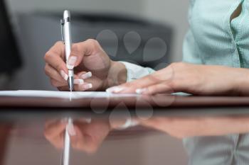Close Up Hands Of Financial Manager Taking Notes When Working On Report
