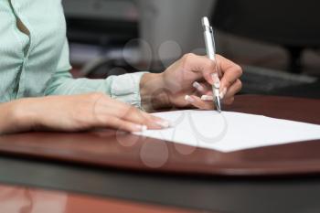Close Up Hands Of Financial Manager Taking Notes When Working On Report