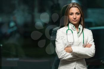 Portrait Of A Beautiful Young Female Doctor Standing Arms Crossed In Office - Successful Woman In Uniform At Work