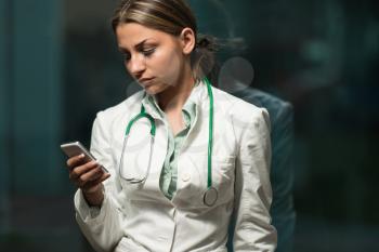 Beautiful Female Doctor Working Taking Notes On Mobile - Healthcare Worker Working Online