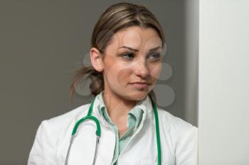 Portrait Of Young Woman Doctor With White Coat Standing In Office - Successful Woman In Uniform At Work
