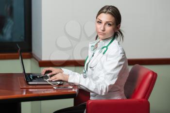 Portrait Of A Young Female Doctor Using Laptop At Office - Healthcare Worker Working Online