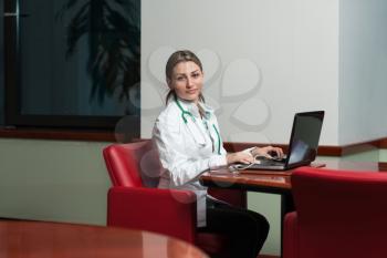 Portrait Of A Young Female Doctor Using Laptop At Office - Healthcare Worker Working Online