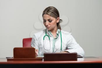 Portrait Of Young Woman Doctor With White Coat Standing In Office - Successful Woman In Uniform At Work