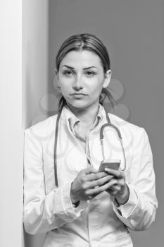 Portrait Of A Young Beautiful Female Doctor Writing Text On Mobile - Healthcare Worker Working Online
