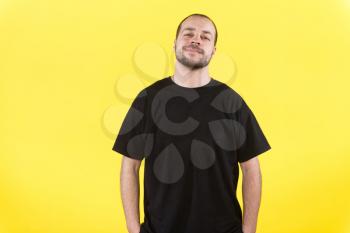 Handsome man wearing black t-shirt isolated over yellow background
