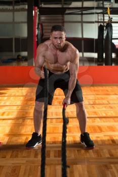 Battling Ropes Young Man At Gym Workout Exercise