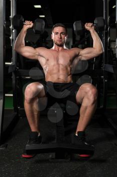 Young Man Working Out Shoulders In A Dark Gym - Dumbbell Concentration Curls