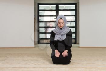 Caucasian Female Muslim Woman Wearing Black Dress And Praying In Mosque