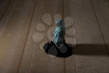 Young Muslim Woman Making Traditional Prayer To God While Wearing A Traditional Hijab And Dress