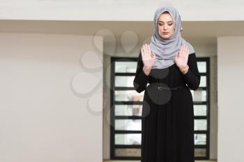 Caucasian Female Muslim Woman Wearing Black Dress And Praying In Mosque