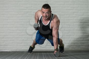 Young Bodybuilder Doing Pushups With Dumbbells As Part Of Bodybuilding Training