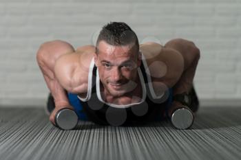 Young Athlete Doing Pushups With Dumbbells As Part Of Bodybuilding Training
