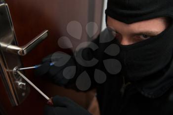 Security - Disguised Burglar Breaking In An Apartment Or Office To Steal Something