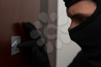 Burglar Breaks Into A Residential Building And Thief In The Mask Covers Peep Hole