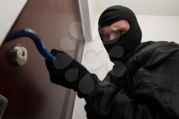 Security - Disguised Burglar Breaking In An Apartment Or Office To Steal Something
