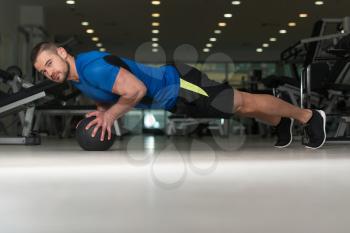 Personal Trainer Doing Pushups With Medicine Ball As Part Of Bodybuilding Training