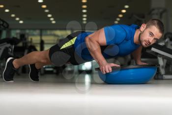 Personal Trainer Doing Pushups On Floor With Bosu Balance Ball As Part Of Bodybuilding Training