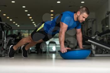 Personal Trainer Doing Pushups On Floor With Bosu Balance Ball As Part Of Bodybuilding Training