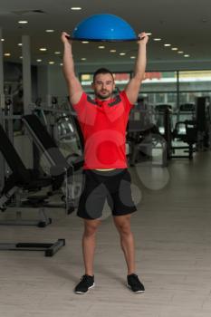 Personal Trainer Doing A Exercise With Bosu Balance Ball As Part Of Bodybuilding Fitness Training