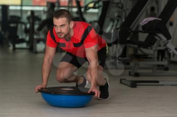 Personal Trainer Doing A Exercise With Bosu Balance Ball As Part Of Bodybuilding Fitness Training
