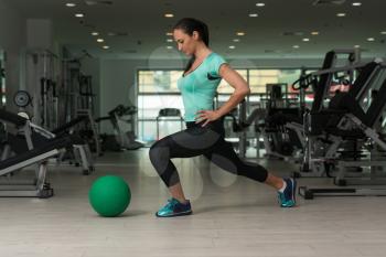 Attractive Woman Doing Stretching With Medicine Ball As Part Of Bodybuilding Training
