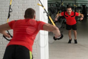Fitness Instructor Exercising Crossfit With Trx Fitness Straps In The Gym's Studio