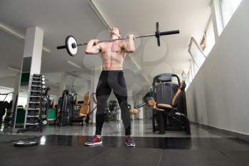 Good Looking And Attractive Man Performing Barbell Squats - One Of The Best Bodybuilding Exercise For Legs