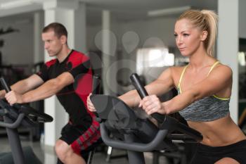 Fitness People Exercising On Bike In A Modern Fitness Center