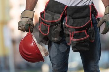 Close Up Of Hard Hat Holding By Construction Worker