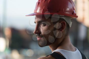 Portrait Of Handsome Male Architect Engineer With Red Helmet