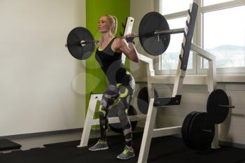 Woman Working Out Legs With Barbell In A Gym - Squat Exercise