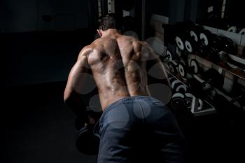 Handsome Bodybuilder Doing Heavy Weight Exercise For Back With Dumbbells