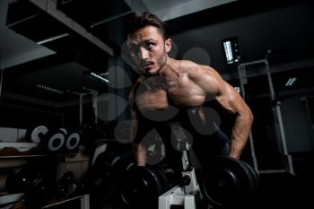 Handsome Bodybuilder Doing Heavy Weight Exercise For Back With Dumbbells