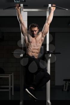 Handsome Man Performing Hanging Leg Raises Exercise - One Of The Most Effective Ab Exercises