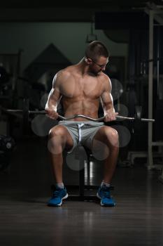 Muscular Nerd Man Doing Heavy Weight Exercise For Biceps With Barbell In Gym
